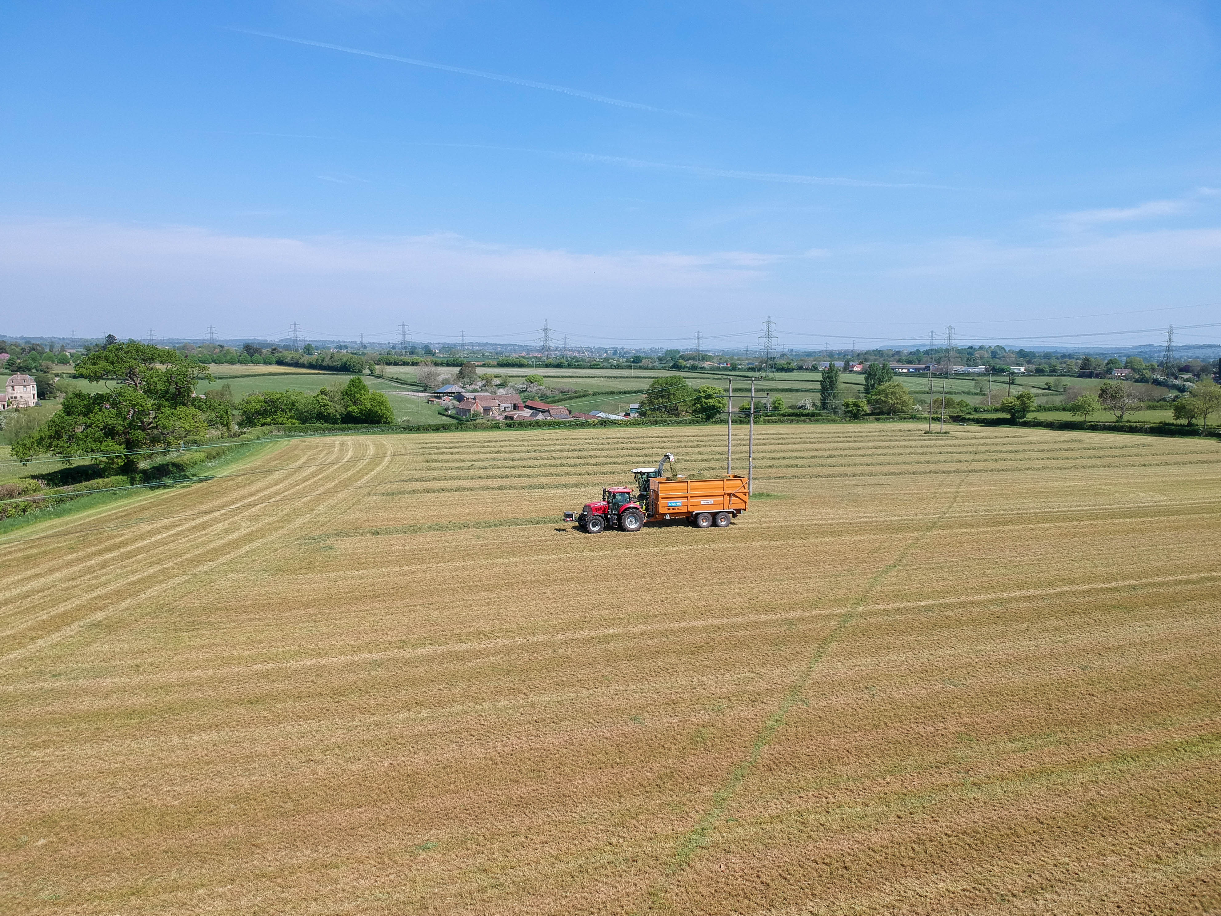 aerial shot of a SW Hire silage Richard Western trailer being pulled by a case 150